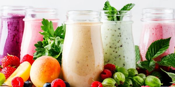 Smoothies for weight loss, 5 smoothies of different colours surrounded by fruit